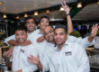 Grupo de tripulantes sonrientes en un ambiente de bar a bordo de un barco