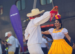 Pareja bailando con trajes tradicionales en un evento cultural al aire libre