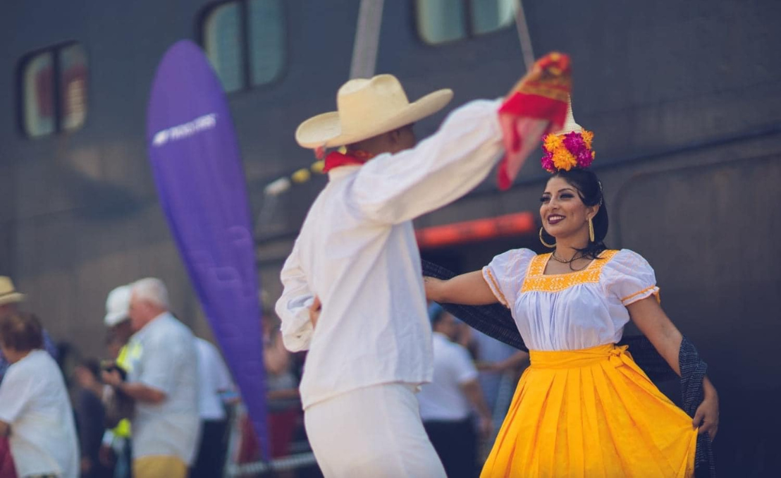 Couple performing traditional dance in cultural attire at an outdoor event