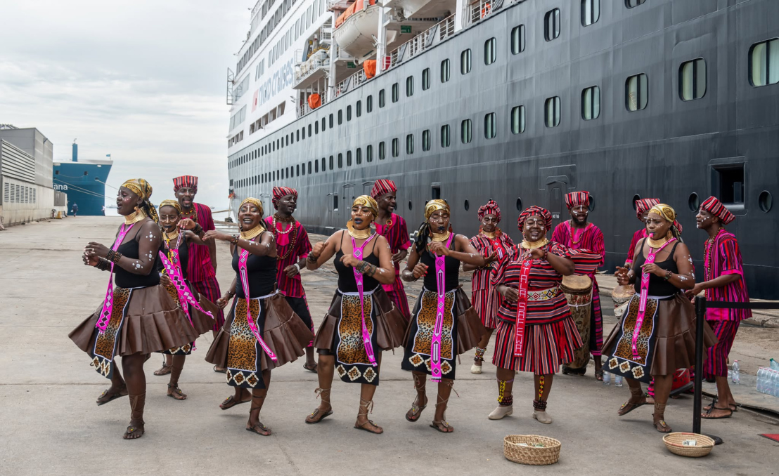 Local performers beside a cruise ship during a port call